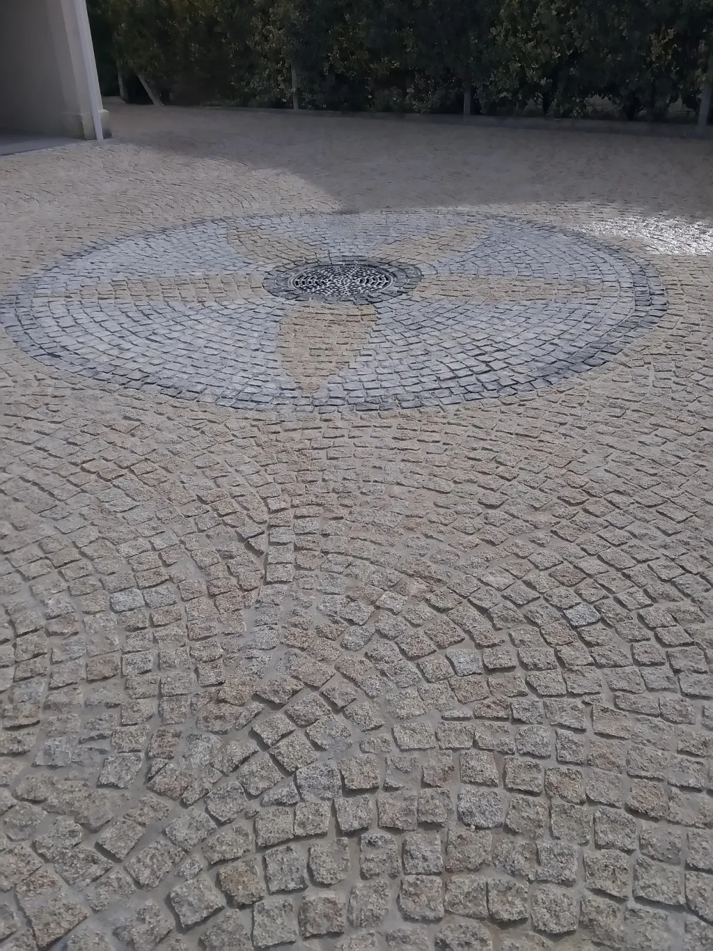 Pavés de pierre posés en rosace sur un sol extérieur